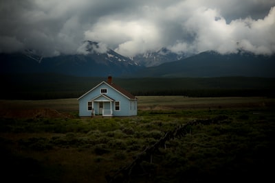 灰色天空下草地上的房子